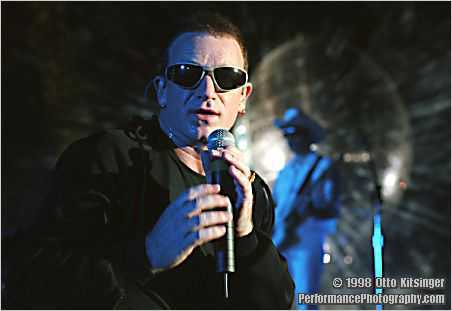 Live concert photo of Bono, The Edge (bg)